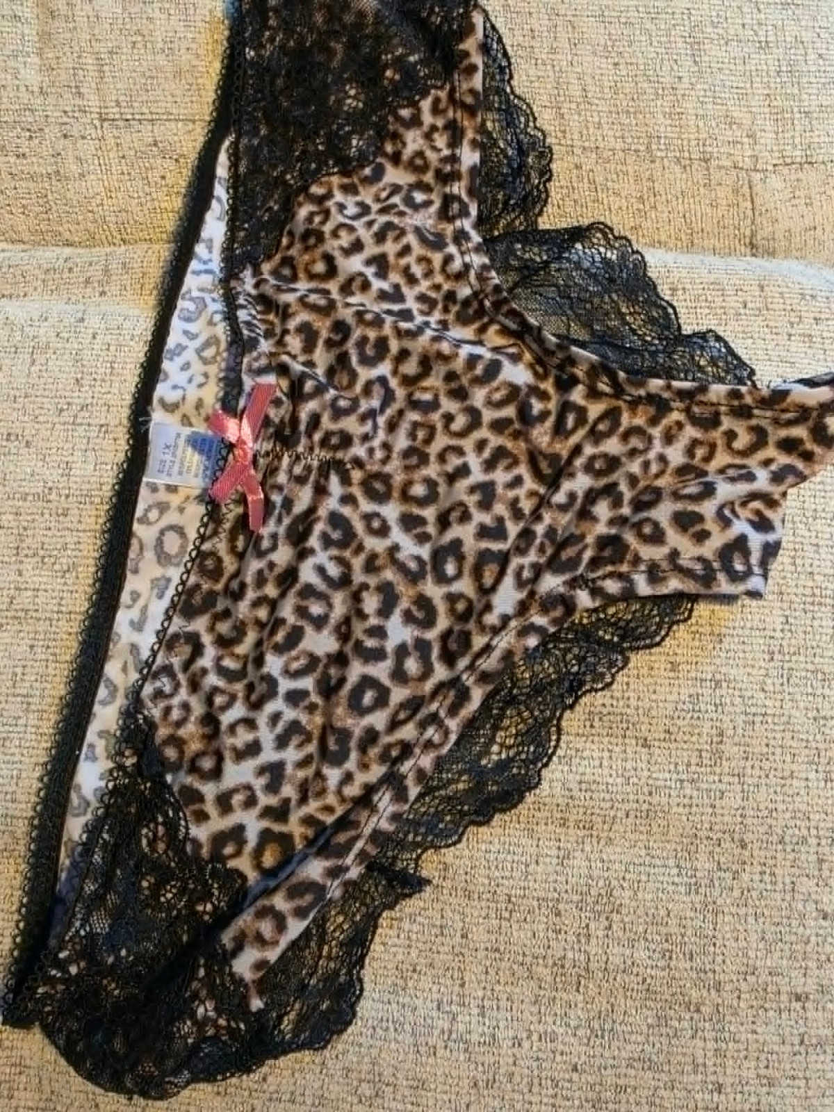 Sexy leopard print panties featuring delicate black lace trim and pink bow